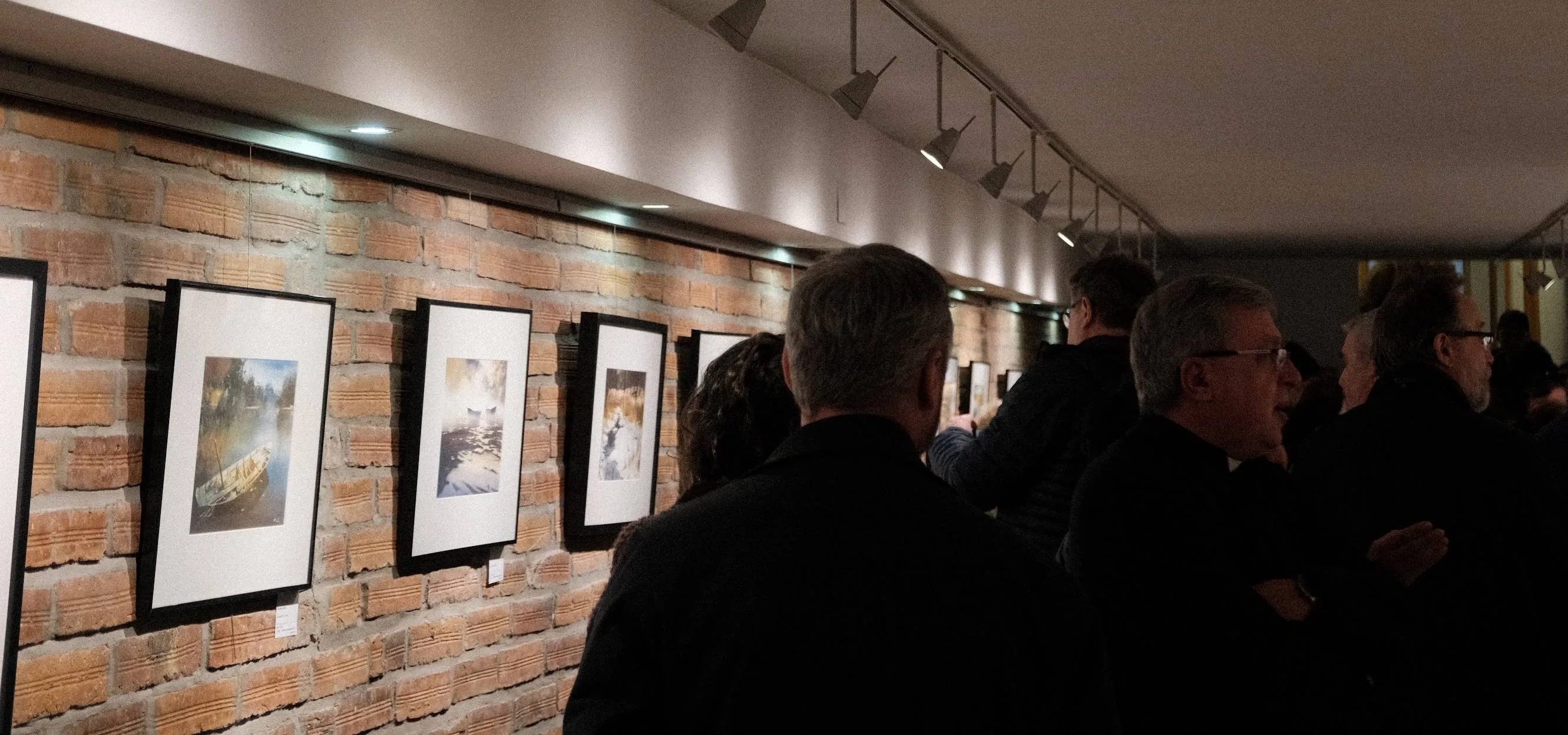 People viewing paintings at the exhibition opening at Galeria Anielska in Warsaw